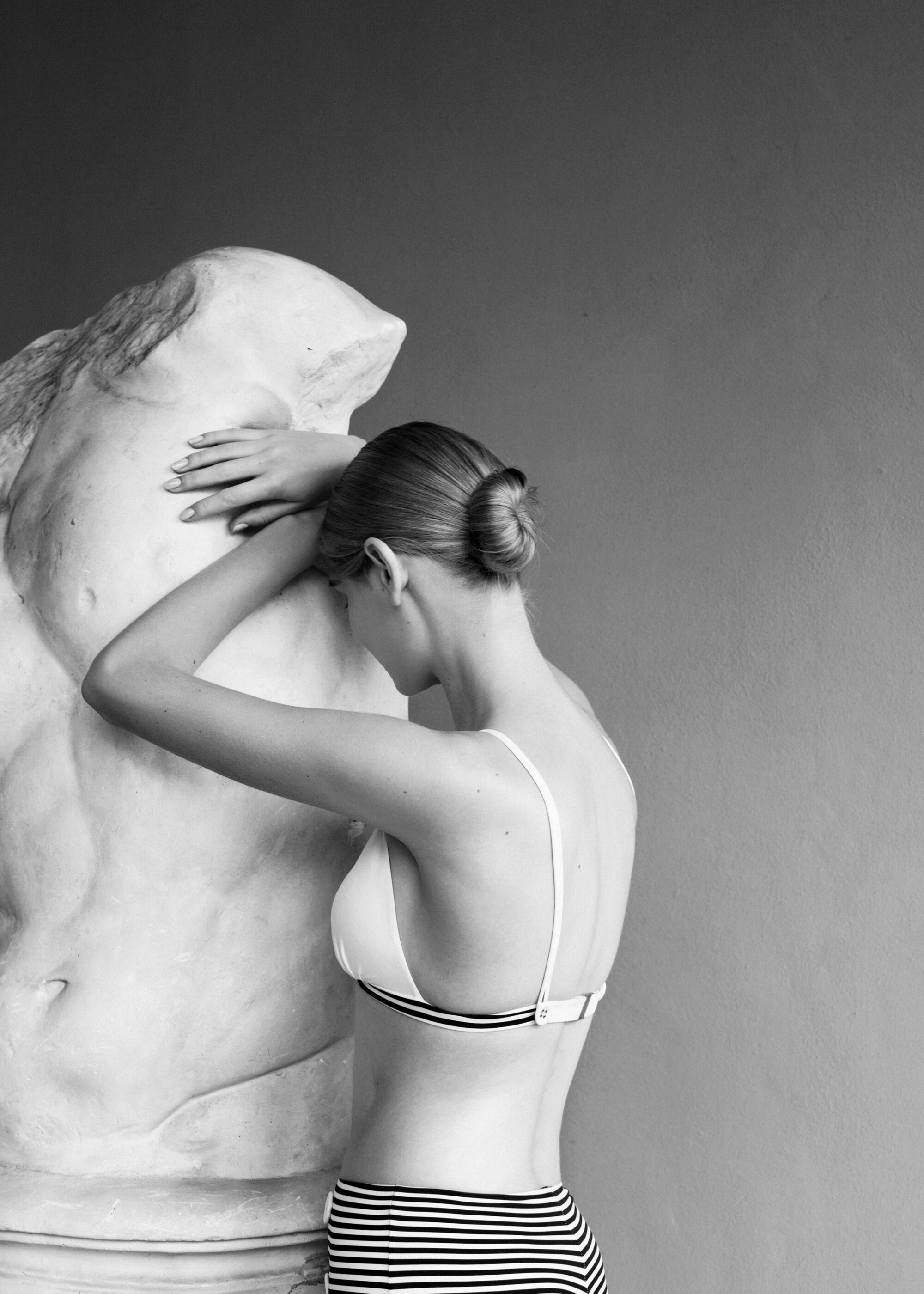 woman in swimwear with sculpture in black and white